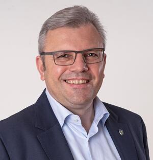 Bild mit ausf&uuml;hrlicher Beschreibung vergr&ouml;&szlig;ern: Portr&auml;tfoto eines Mannes mit Brille.