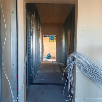 Bild mit ausf&uuml;hrlicher Beschreibung vergr&ouml;&szlig;ern: Foto vom Innenbereich, zu sehen ist ein Flur in Trockenbau Weise sowie die Elektrik, noch im Ausbau