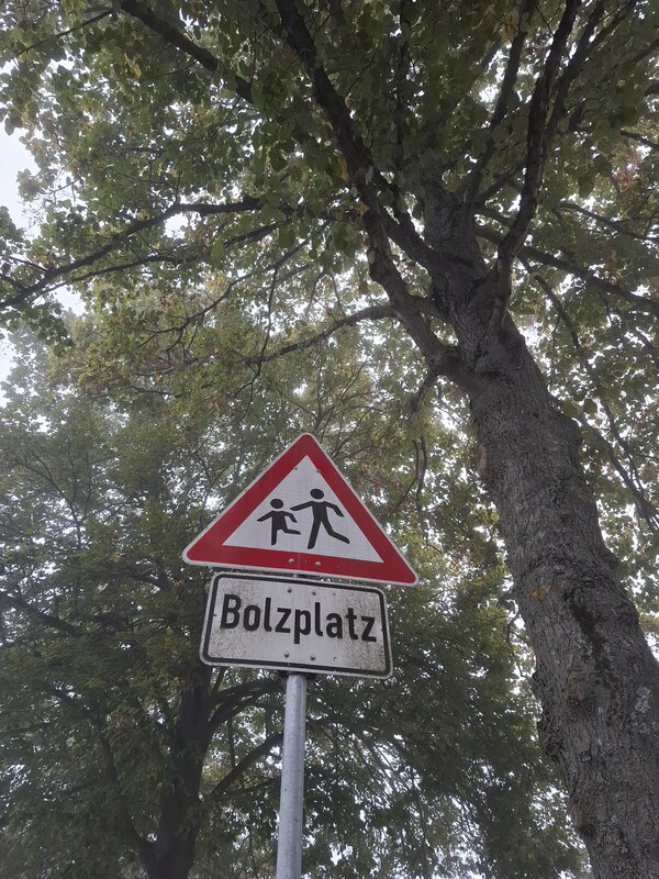 Das Bild zeigt ein dreieckiges Verkehrszeichen mit spielenden Kindern und rotem Rand. Darunter ist der Schriftzug Bolzplatz zu lesen. - Zum Artikel: Zwei Bolzpl&auml;tze gesperrt
